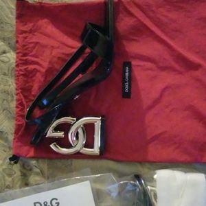 A pair of very shiny jet black open toe Dolce & Gabbana heels.